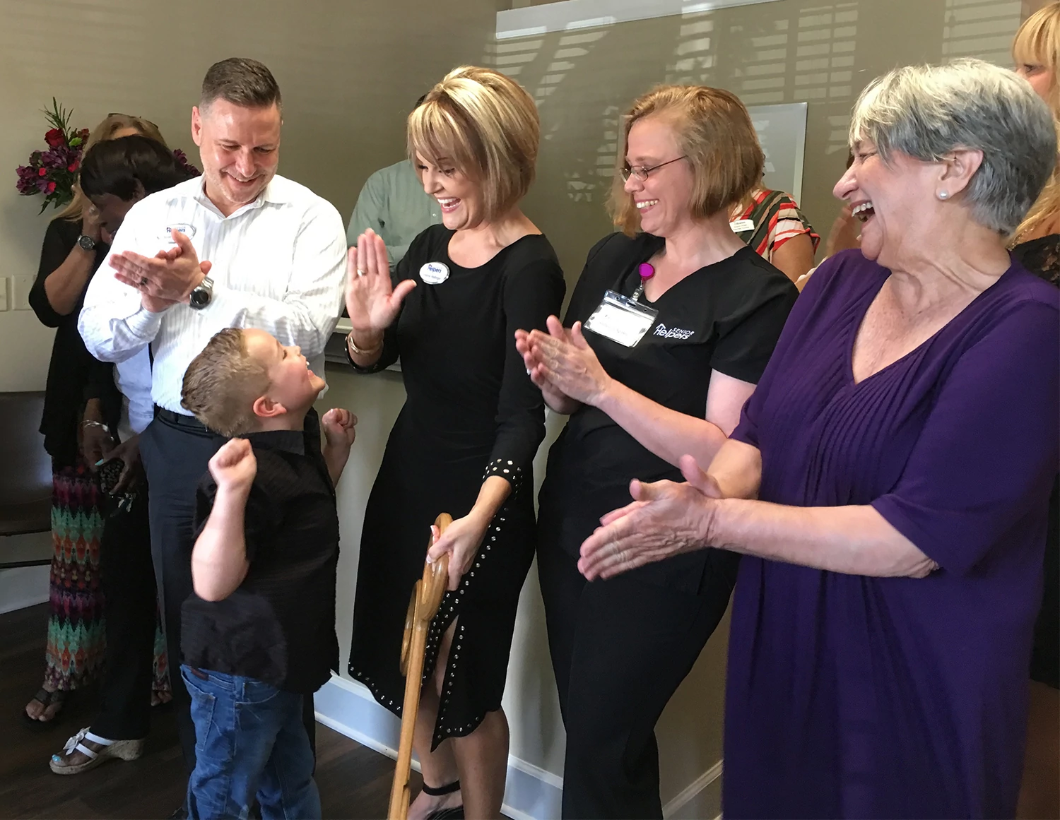 Cole Wellinger, 7, celebrates with his mother, Christine, and father, Scott, just after the family cut the ribbon May 3 at the Grand Opening of their new enterprise, Senior Helpers located in Moss Creek Village