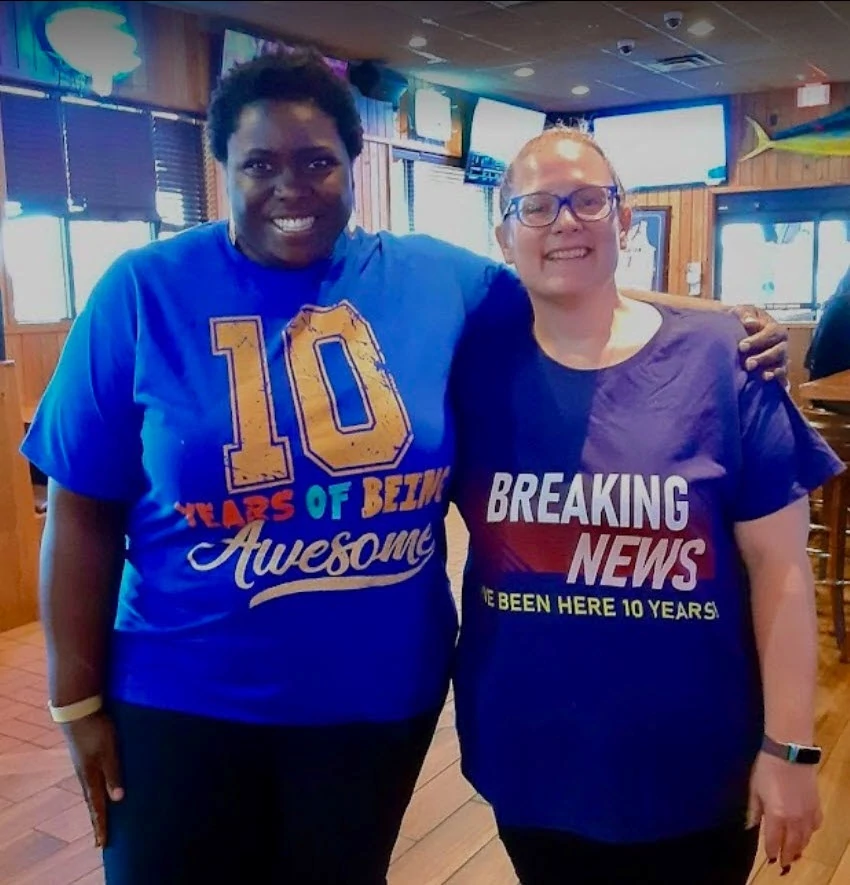 Senior Helpers Orlando staff members and executive director gathered to commemorate the director’s 10th anniversary with Senior Helpers. This photo shows staff member Jamila McFarlane (left) and Executive Director Aubrie Depkin at a staff gathering.