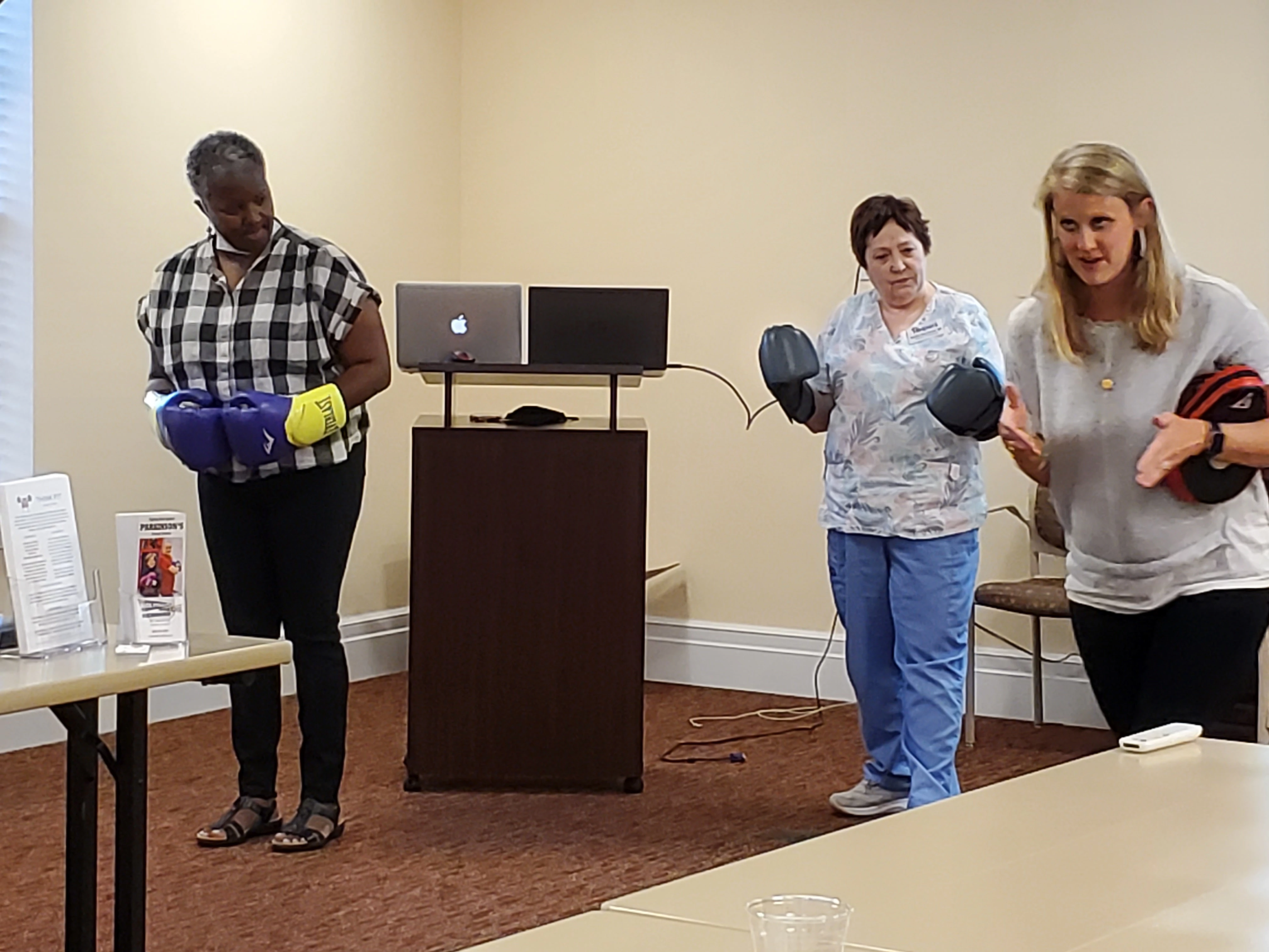 On September 14, 2022 Senior Helpers partnered with Rock Steady Boxing to give a presentation to the Case Management Society of VA in Midlothian, VA. Pictured is Lindsay Nexsen of Rocky Steady Boxing showing Kathie Matthews, CMSA/Senior Helpers and Kelva Waller of CMSA an example on how simple boxing maneuvers can assist with the challenges of neuromuscular diseases such as Parkinson’s.