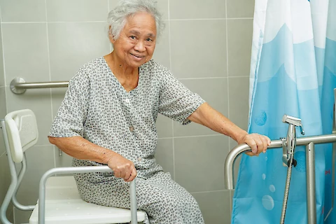 https://www.seniorhelpers.com/site/assets/files/424853/senior-woman-holding-grab-bar-while-using-the-toilet.480x0.webp