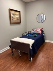 In the bedroom/ bathroom space, you will notice a hospital bed as well as a Hoyer lift.  Again, several fall risks have been added to keep the space as real life as possible. On the inside wall, there are items to aid in a bathroom setting.