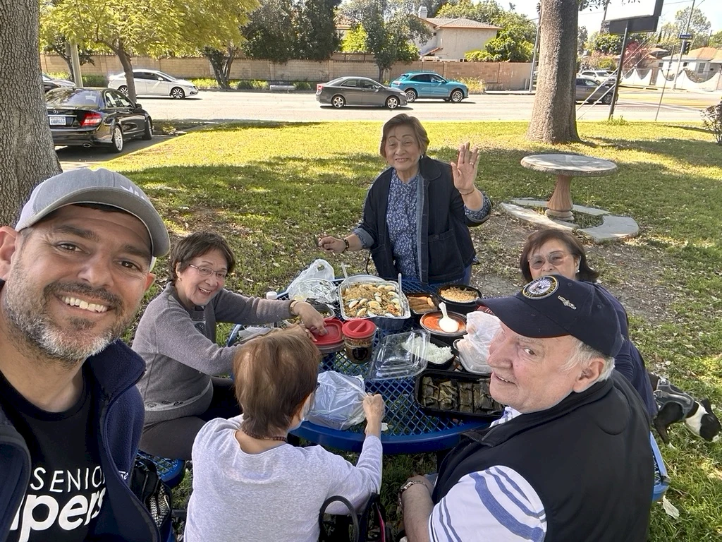 Owner, Slade Abisror, enjoying the lovely weather with an outdoor picnic and the best company—our seniors!